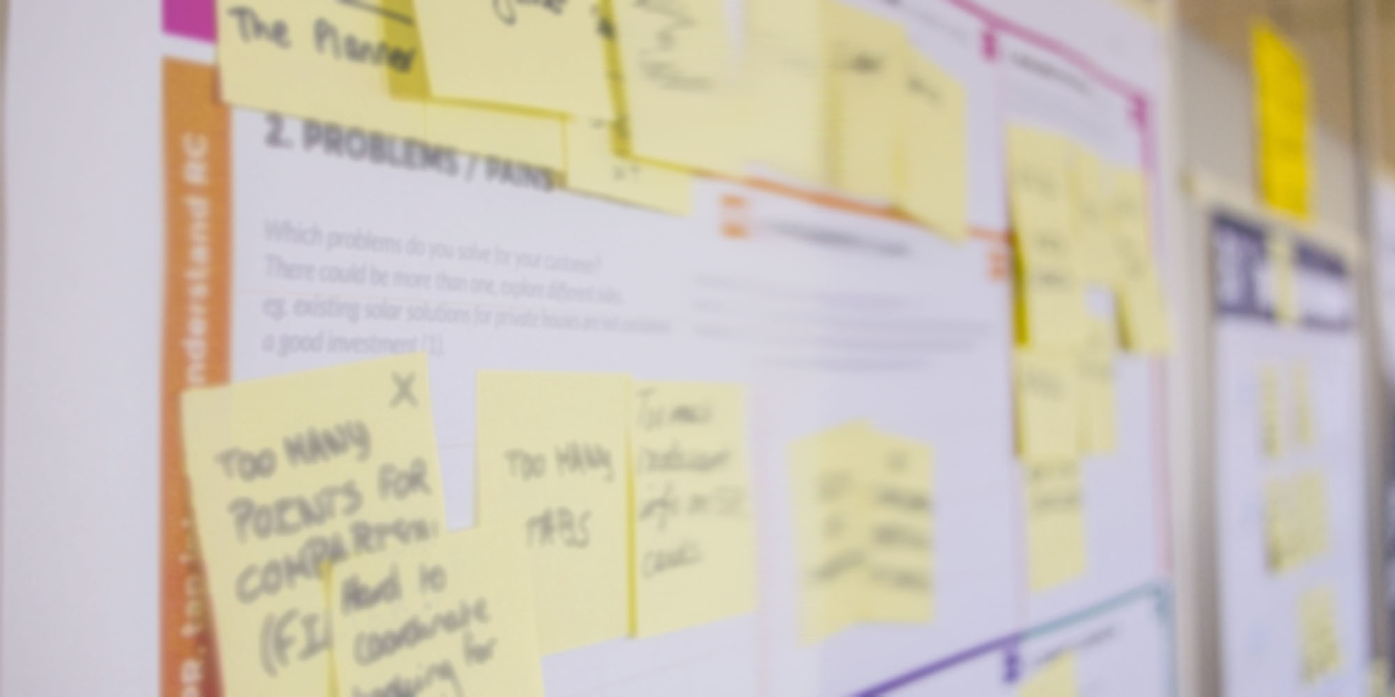 Notice board filled with pinned yellow notes. Blurred