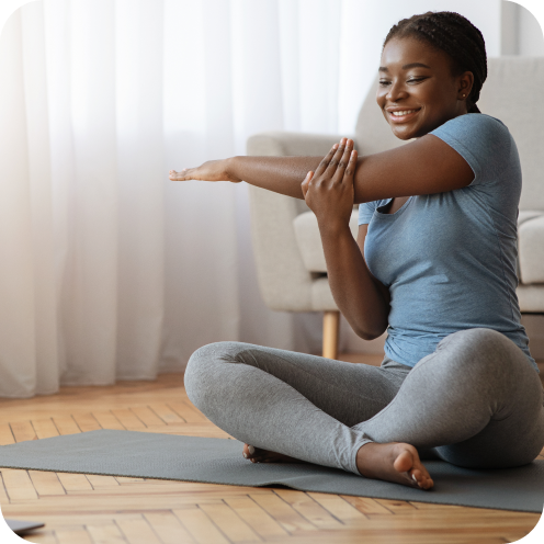 Cheerful African Woman Stretching Up In Front Of Laptop, Doing Home Workout